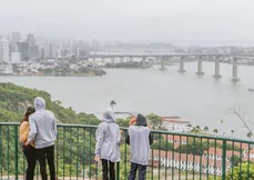 Com roupas de frio, moradores  observam a baía de Vitória