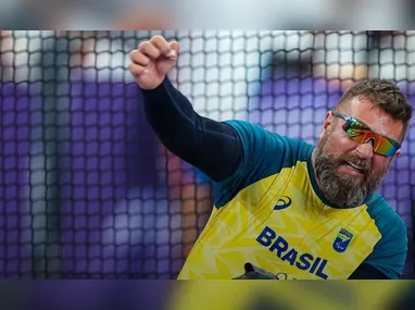 Mari Gesteira, com a medalha conquistada na prova dos 100 metros costa (S9), e o técnico Leonardo Miglinas