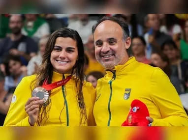 Mari Gesteira, com a medalha conquistada na prova dos 100 metros costa (S9), e o técnico Leonardo Miglinas