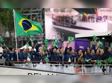 Delegação do Brasil passa de barco pelo Rio Sena enquanto dançarinas de cancan se apresentam durante a cerimônia de abertura dos Jogos Olímpicos de Paris 2024, na França