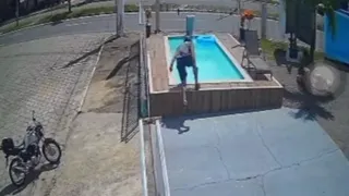 Imagem ilustrativa da imagem VÍDEO | Homem desce de moto e mergulha de capacete em piscina de loja no ES