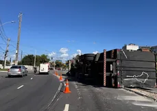 Imagem ilustrativa da imagem Carreta carregada de pneus tomba ao realizar curva na Vila Rubim