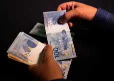 Dinheiro na mão: alerta para golpes com falsas promessas de ressarcimento antecipado dos descontos indevidos.