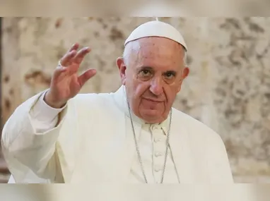 Mulher deixa rosário perto de velas com a foto do papa Francisco do lado de fora do Hospital Policlínico Universitário Agostino Gemelli, em Roma, na Itália, onde o pontífice segue internado