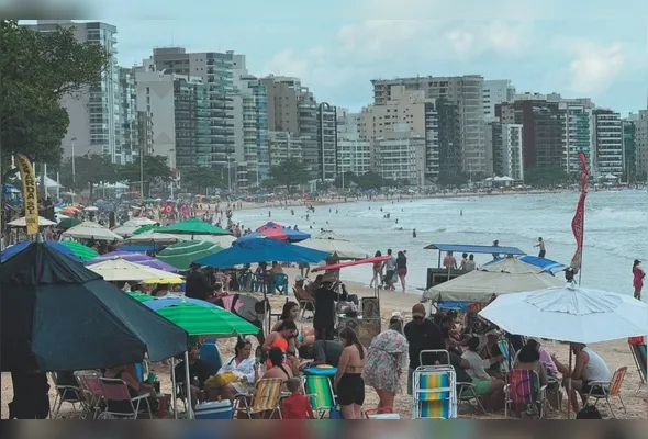 Banhistas curtem praia em Guarapari: semana de folga atrai mais turistas, aumentando o movimento no litoral