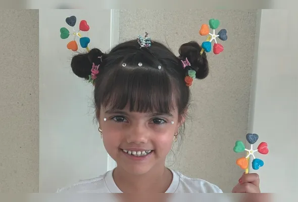 Maria Clara foi para a escola com um catavento de pirulitos no cabelo