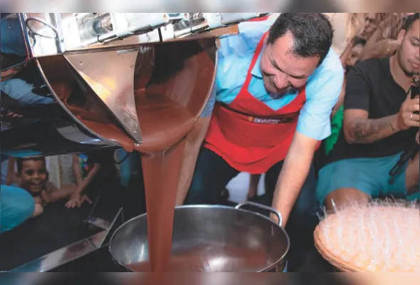 Momento do tombo do chocolate: 
mais de uma tonelada do doce é despejada em uma calha gigante