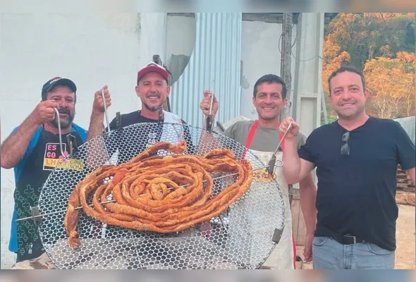 Marco Aurélio Mosquini,  Marcelo Mosquini, Cristiano Bravim  e Ricardo  Dalcin mostram o torresmo gigante, destaque da culinária de Vargem Alta