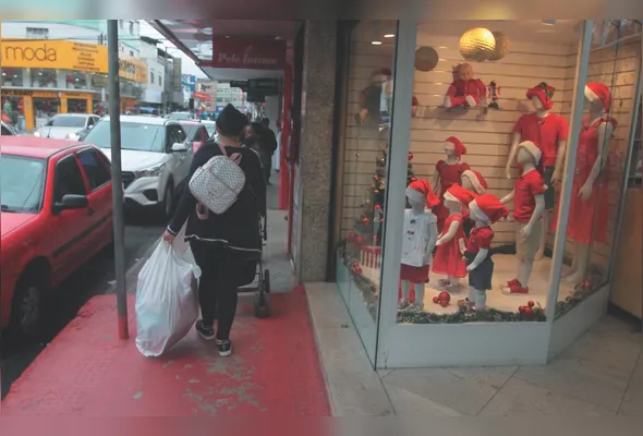 Vitrine de loja com decoração de Natal e movimento de clientes nas ruas. Policiamento será reforçado nesta época