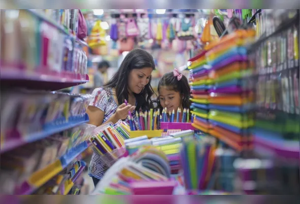 Mãe e filha fazem compras de material escolar: variações de preços