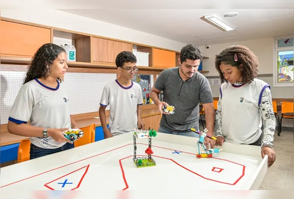 O professor Leandro Nunes com os alunos Enzo Gabriel, Isabela Freitas e Ana Clara Paixão na sala maker