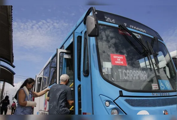 Ônibus com o adesivo indicando a paralisação prevista para terça-feira