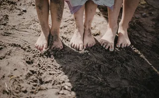 Imagem ilustrativa da imagem Deitar e brincar na terra, na grama e na areia pode causar doenças