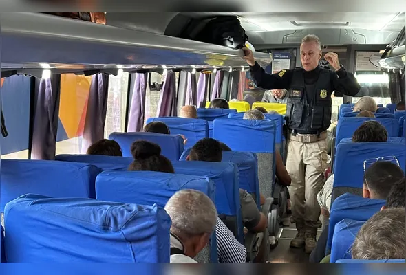 Policial durante  ação em ônibus para reforçar a importância da contenção da violência contra a mulher