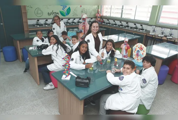 A professora de Ciências Rayane Rosa de Souza mostra aos alunos alguns objetos do laboratório da escola