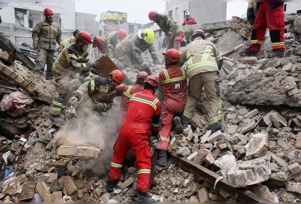 Equipes de resgate buscam sobreviventes nos escombros após um ataque aéreo no sul de Teerã, no Irã, nesta sexta-feira