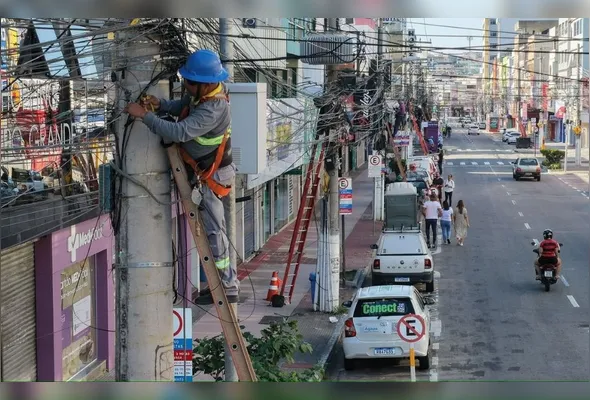 Funcionários realizam a retirada de fios desativados em Campo Grande