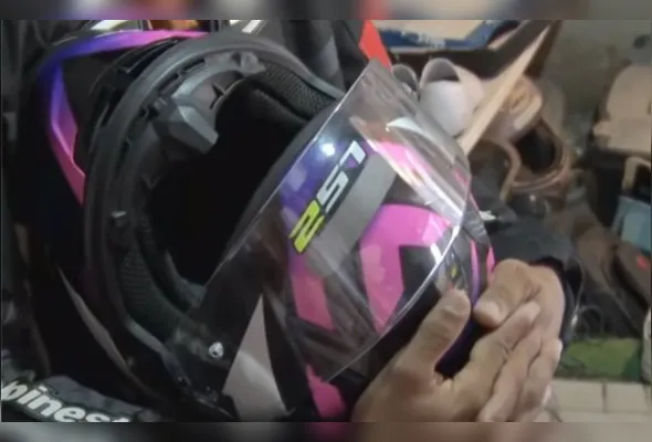 Pai mostra o capacete do filho