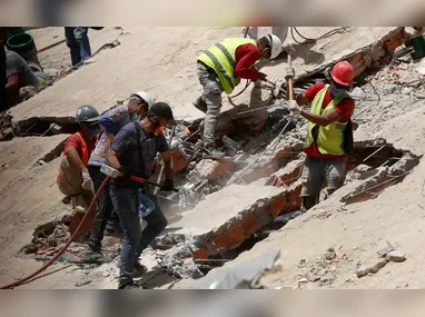 Policial venezuelano procura por vítimas em meio aos escombros de construções que desabaram em La Guaira, na Venezuela
