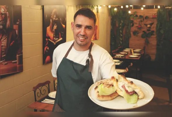 O pizzaiolo Ernesto Gonçalves mostra o sanduíche de filé mignon  finalizado e pronto para ser servido