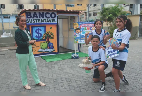 Ângela, Lídia, Calebe e Mayza, da Escola Terfina Rocha Ferreira, em Itacibá, Cariacica, mostram o cartão eletrônico e 
o “dinheiro”, chamado de leonça, do Banco Sustentável da escola