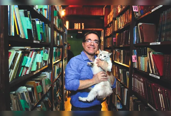 Sandro Praça, dono da livraria, com a gata Juliette:  “As pessoas estavam carentes de um ambiente como esse”
