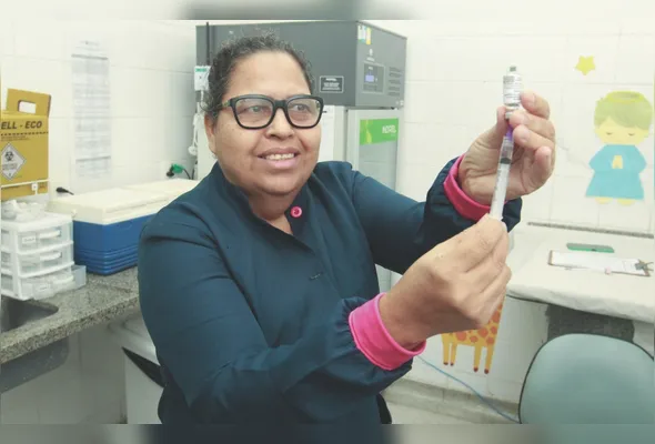 Wanuza Maria Ferreira mostra a vacina MenQuadfi, que protege contra os sorogrupos A, C, W e Y