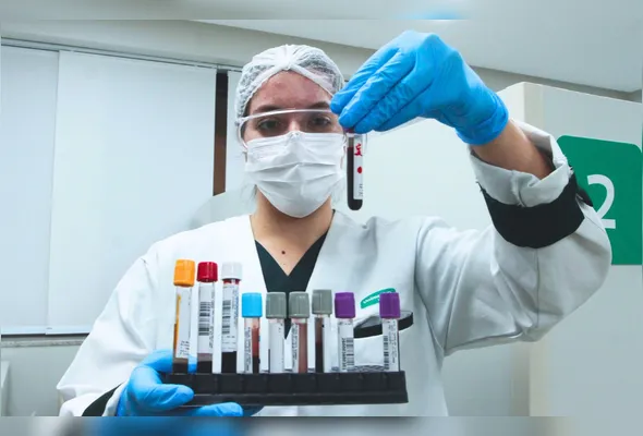 Laiza da Ávila mostra tubos utilizados na coleta das amostras de  sangue para realização dos exames
