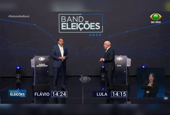 Conforme sorteio prévio, Flávio Bolsonaro ocupa o lado esquerdo do cenário, enquanto Lula fica posicionado no lado direito