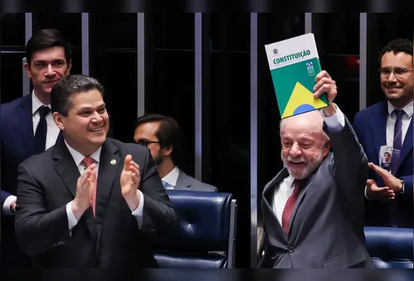 Presidente Luiz Inácio Lula da Silva erguendo um exemplar da Constituição Federal durante a cerimônia de promulgação da Proposta de Emenda à Constituição (PEC) que encerra a escala de trabalho 6x1
