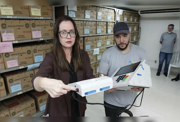Lívia Fernandes, chefe do cartório da 32ª Zona Eleitoral, com o técnico Athos de Abreu Vieira, que atua na preparação das urnas para a votação de amanhã
