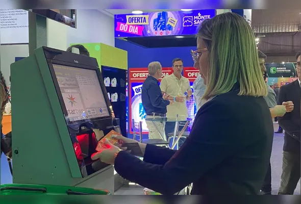 Tamires Gaseta mostra o posto de autoatendimento, que requer investimento de R$ 18 mil a R$ 21 mil, no evento