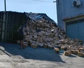 Imagem ilustrativa da imagem Caminhão carregado com sacolas tomba e bloqueia rua de Cariacica