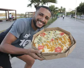 Imagem ilustrativa da imagem Influencer baiano distribui pizza  na orla da Camburi