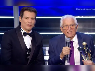Carlos Alberto de Nóbrega, com o troféu na mão, ao lado do apresentador Celso Portiolli