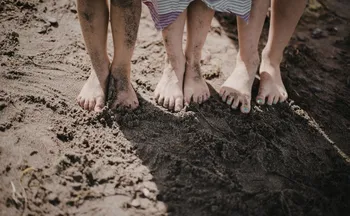 Imagem ilustrativa da imagem Deitar e brincar na terra, na grama e na areia pode causar doenças