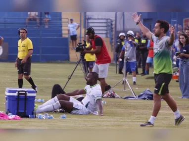 Criança é levantada por um adulto para conseguir fazer uma cesta