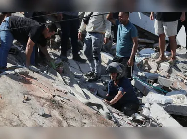 Equipes de resgate e moradores vasculham os escombros após um   terremoto atingir a cidade de Cali, na Colômbia, nesta segunda-feira