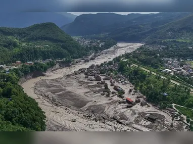 Residentes observam estruturas danificadas após enxurrada atingir a região de Devighat, no distrito de Nuwakot, no Nepal