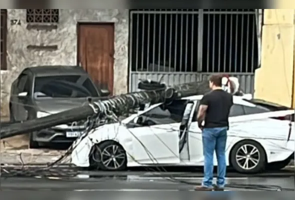 O poste ficou caído sobre o carro e os fios espalhados pelo chão