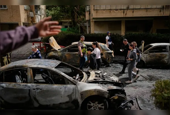 Forças de segurança israelenses e equipes de resgate inspecionam um local atingido por um míssil iraniano em Petah Tikva, Israel, nesta terça-feira, 31 de março de 2026