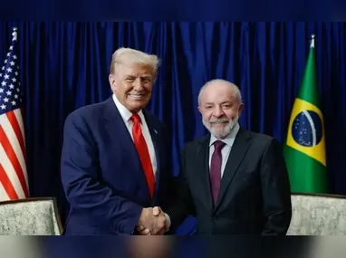 Navios de carga, incluindo graneleiros e navios de carga geral, estão ancorados ao largo da costa, enquanto uma pequena lancha passa em primeiro plano, no Estreito de Ormuz, perto de Bandar Abbas, no Irã