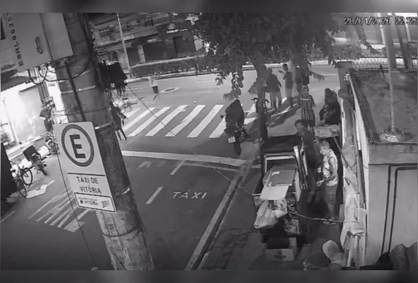 Imagens de uma câmera de videomonitoramento mostram o momento em que um homem se aproxima do grupo e faz disparos