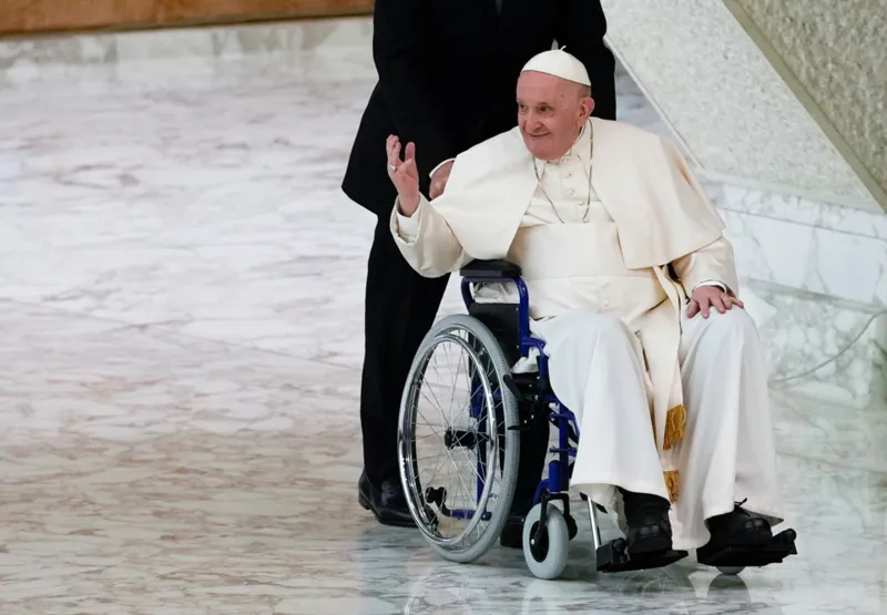 Papa Francisco chega em uma cadeira de rodas para assistir a uma audiência com freiras e superiores