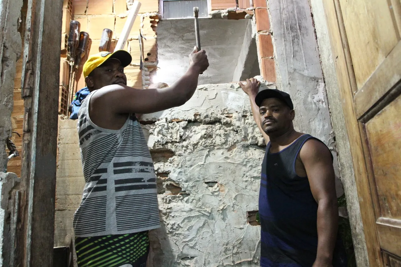 Edilson Gomes, de 40 anos, e Heliomar Vieira, 43 anos, quebraram a parede para retirar a idosa