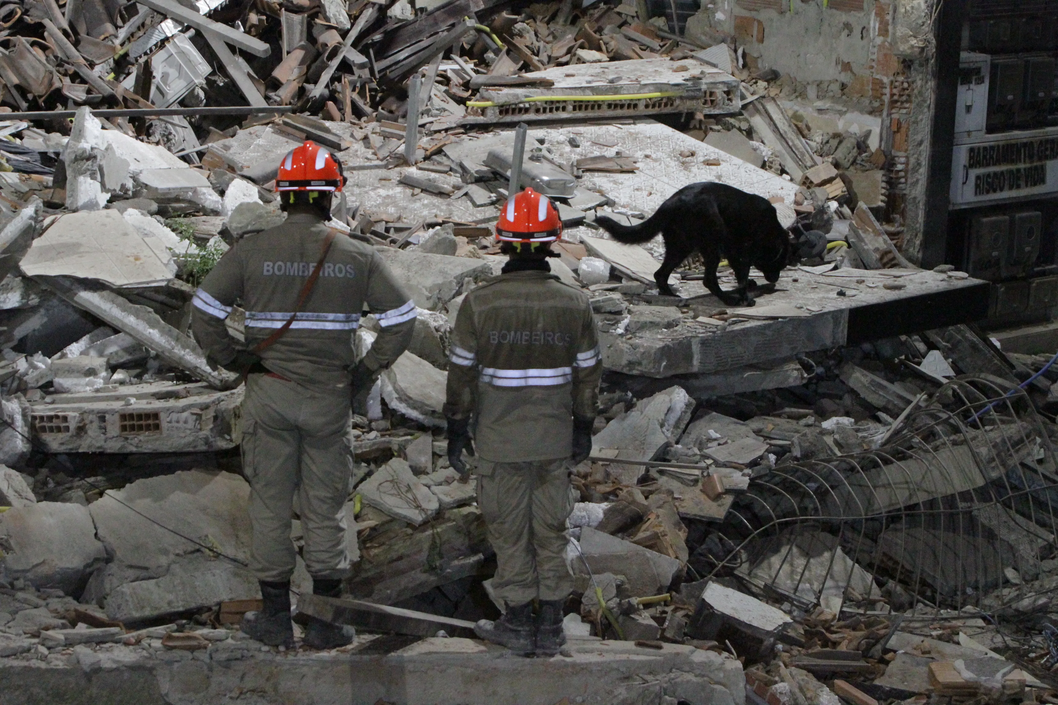 Cenário de destruição: Bombeiros no local da tragédia, onde morreram o pai, a irmã e a sobrinha de Larissa