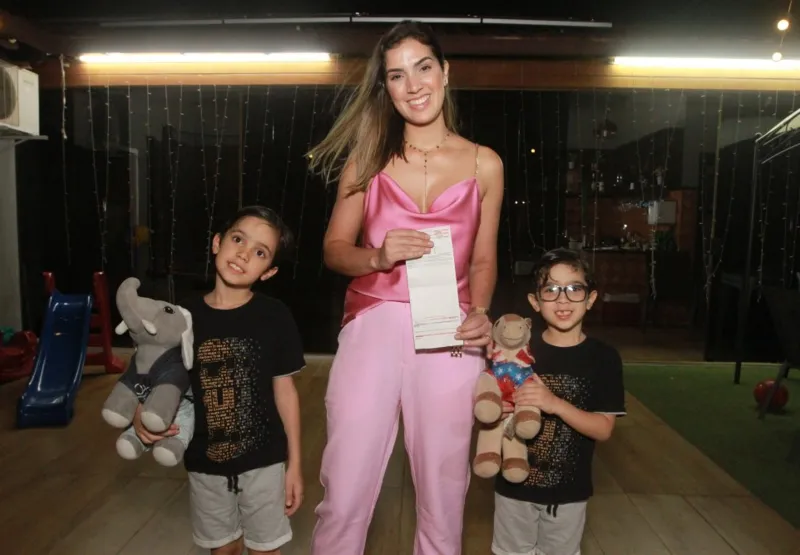 Karyna Araújo mostra a conta de energia, ao lado dos filhos Lucas e Gael. “Sentimos a economia desde o primeiro mês”, disse ela.