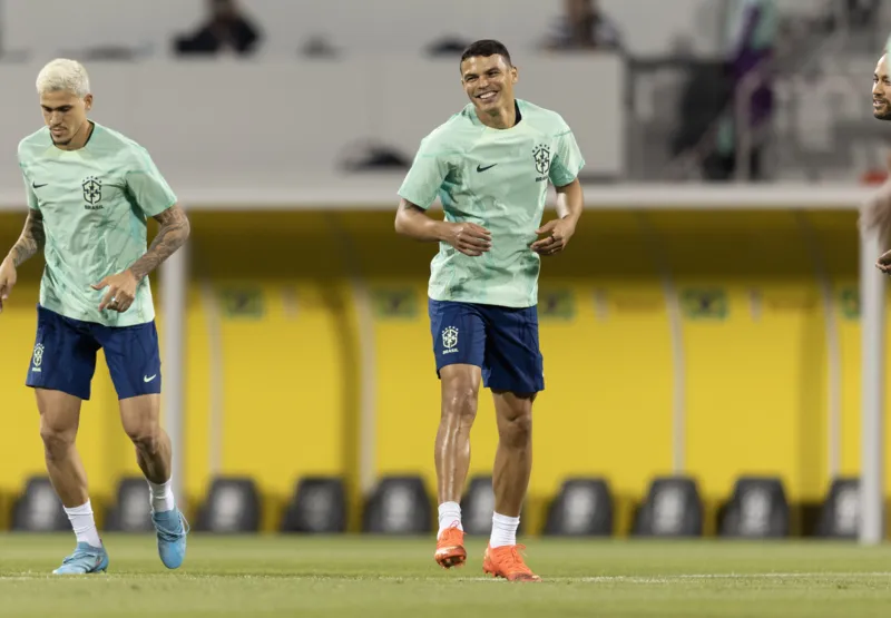 Com sorriso no rosto, Thiago Silva corre ao lado de Pedro durante treino.