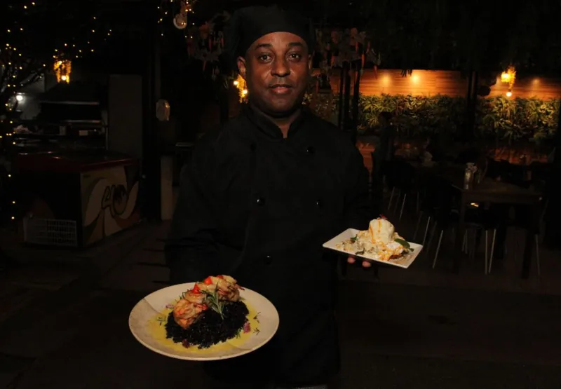 O chef Marcos José Rodrigues Gomes com os pratos de sua autoria, o salmão negro e o abacaxi havaiano