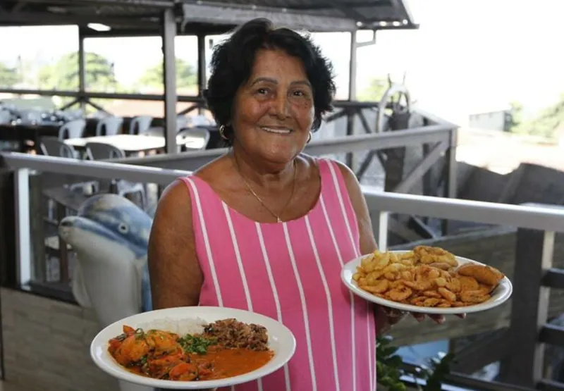 Esinete Mattos, a Dona Nete, mostra dois pratos com frutos do mar que estarão disponíveis no evento